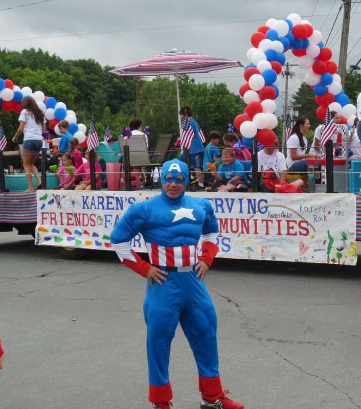 Shortly after 11 am, the parade appeared.  Captain America, our own Mark, was not on the official parade roster.  But that did not stop him from escorting the entourage from start to finish!